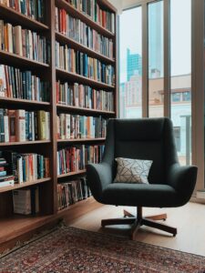 A chair sits by a shelf of books