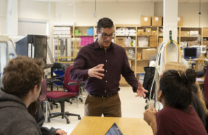 Teacher standing and gesturing to a group of students